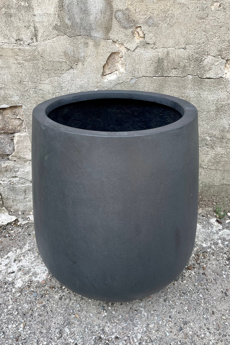 detail of the top of Pax Pot Fiberstone Black Medium against a grey wall 