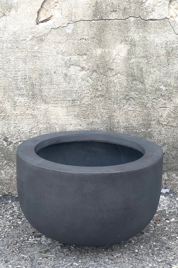 A full frontal view of Sunny Fiberstone Pot Grey Medium against concrete backdrop