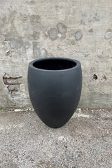 Detail of the top of the Bond Planter Black Medium against a grey wall