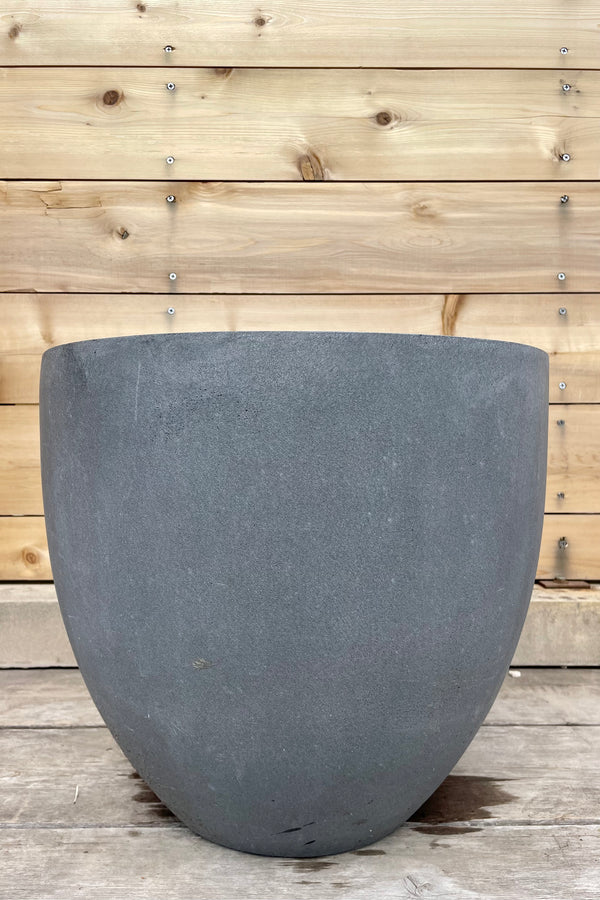 Jesslyn Pot Fiberstone grey small against a fence