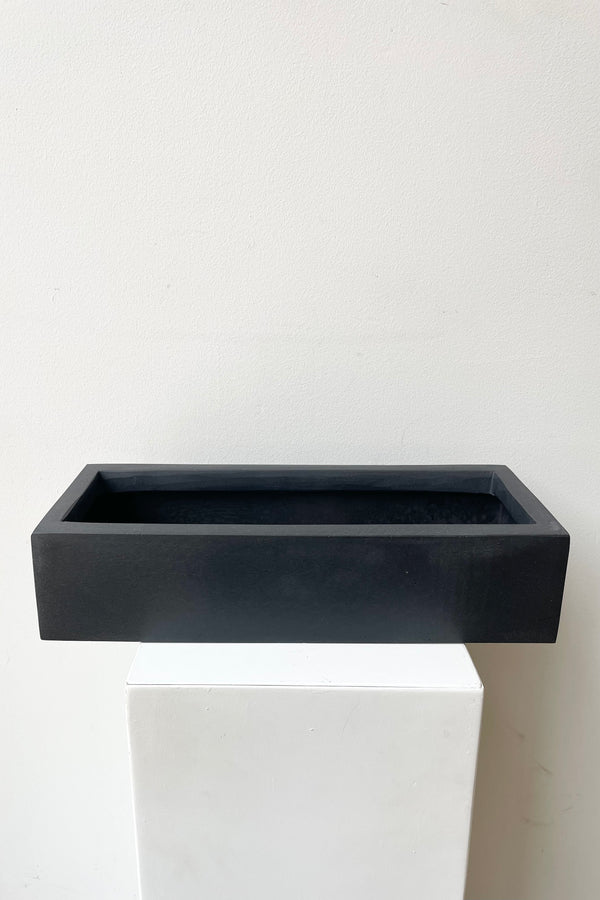detail of the top of Balcony Planter Slim Low Black Extra Small against a white wall