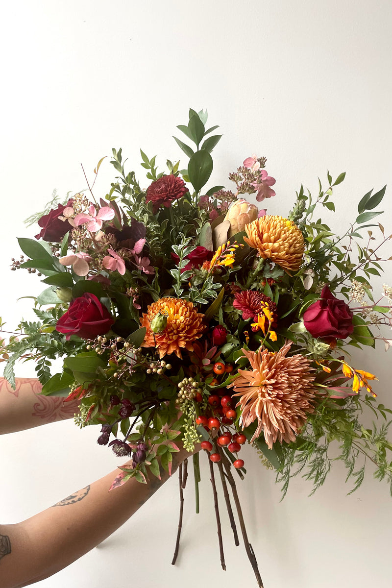 Hands hold an example of fresh Floral Arrangement Earth from Sprout Home Floral in Chicago