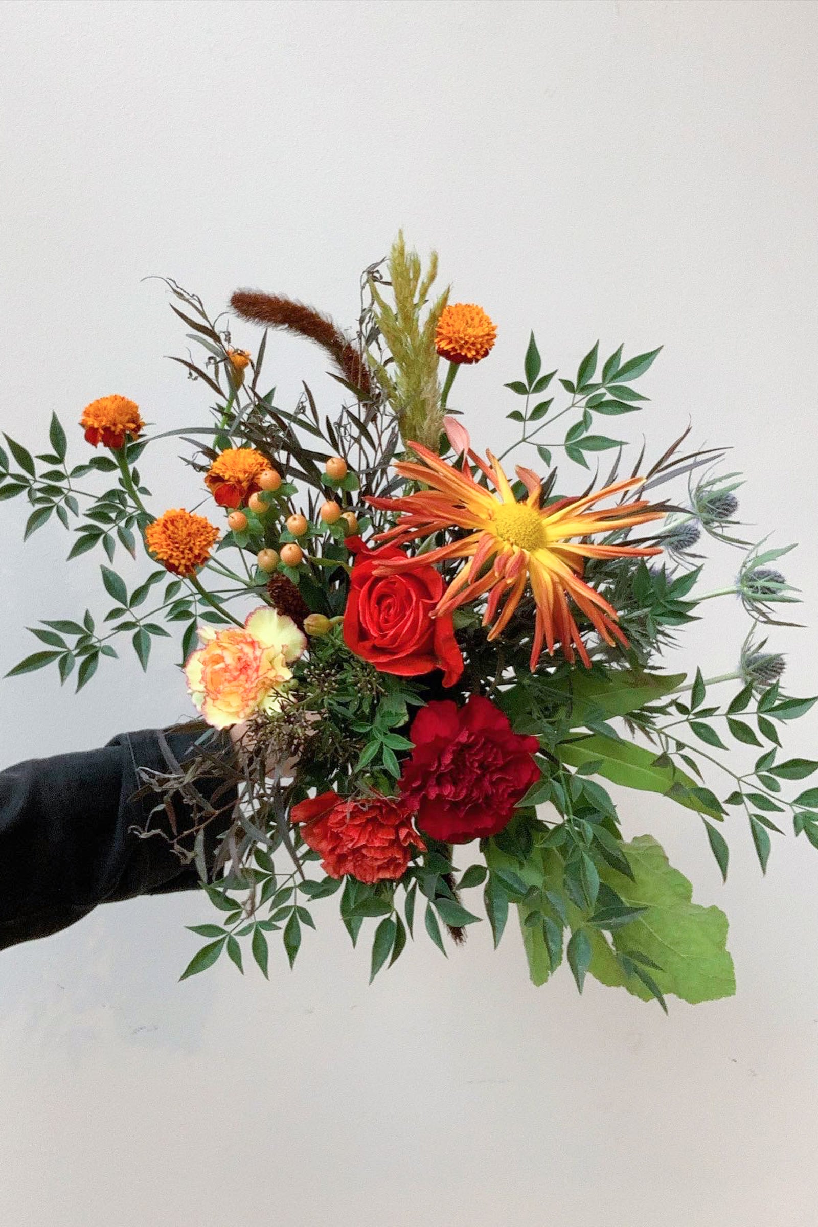 Custom Floral arrangement by Sprout Home in warm colors being held in hand ©Sprout Home #size_$75