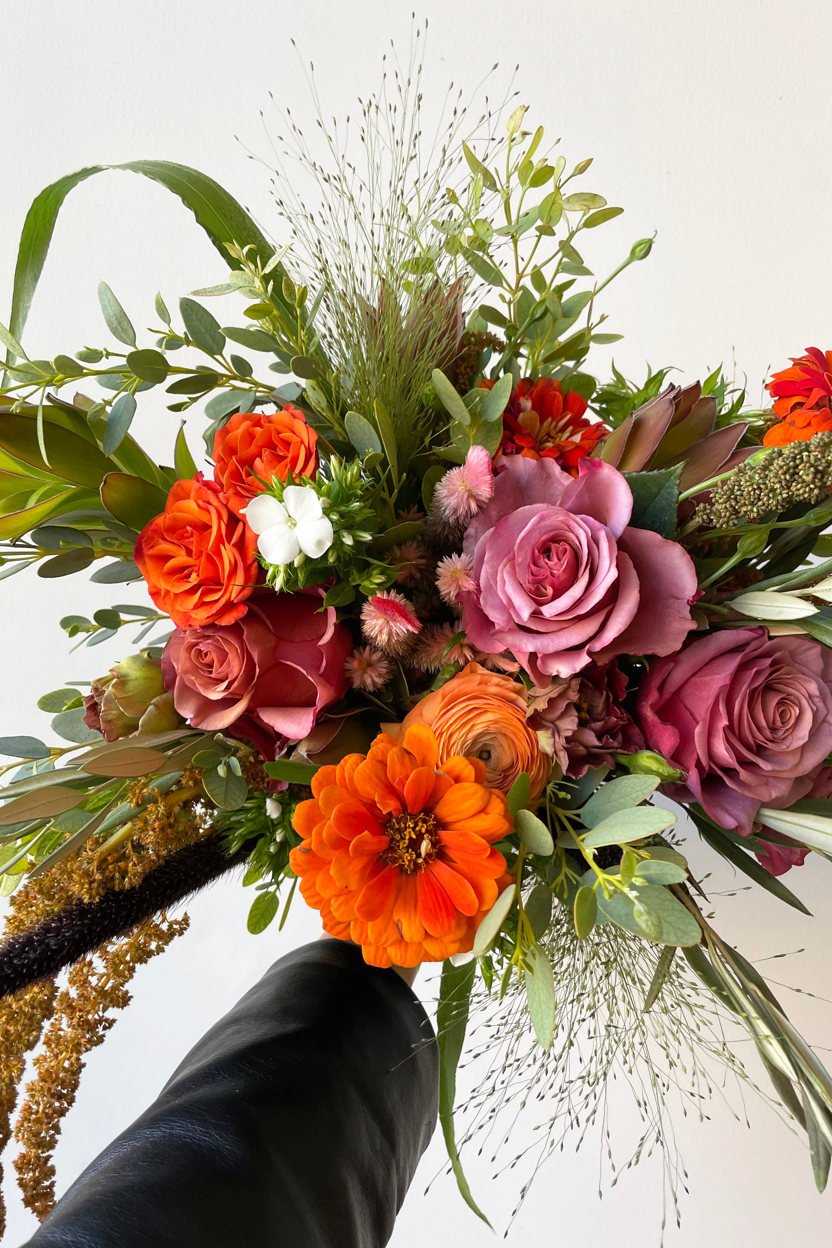 A hand holds an example of fresh Floral Arrangement Midday from Sprout Home Floral in Chicago #size_$90