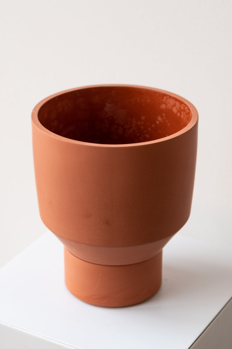 The Northern Habitat Funnel Planter terracotta on a white surface in a white room