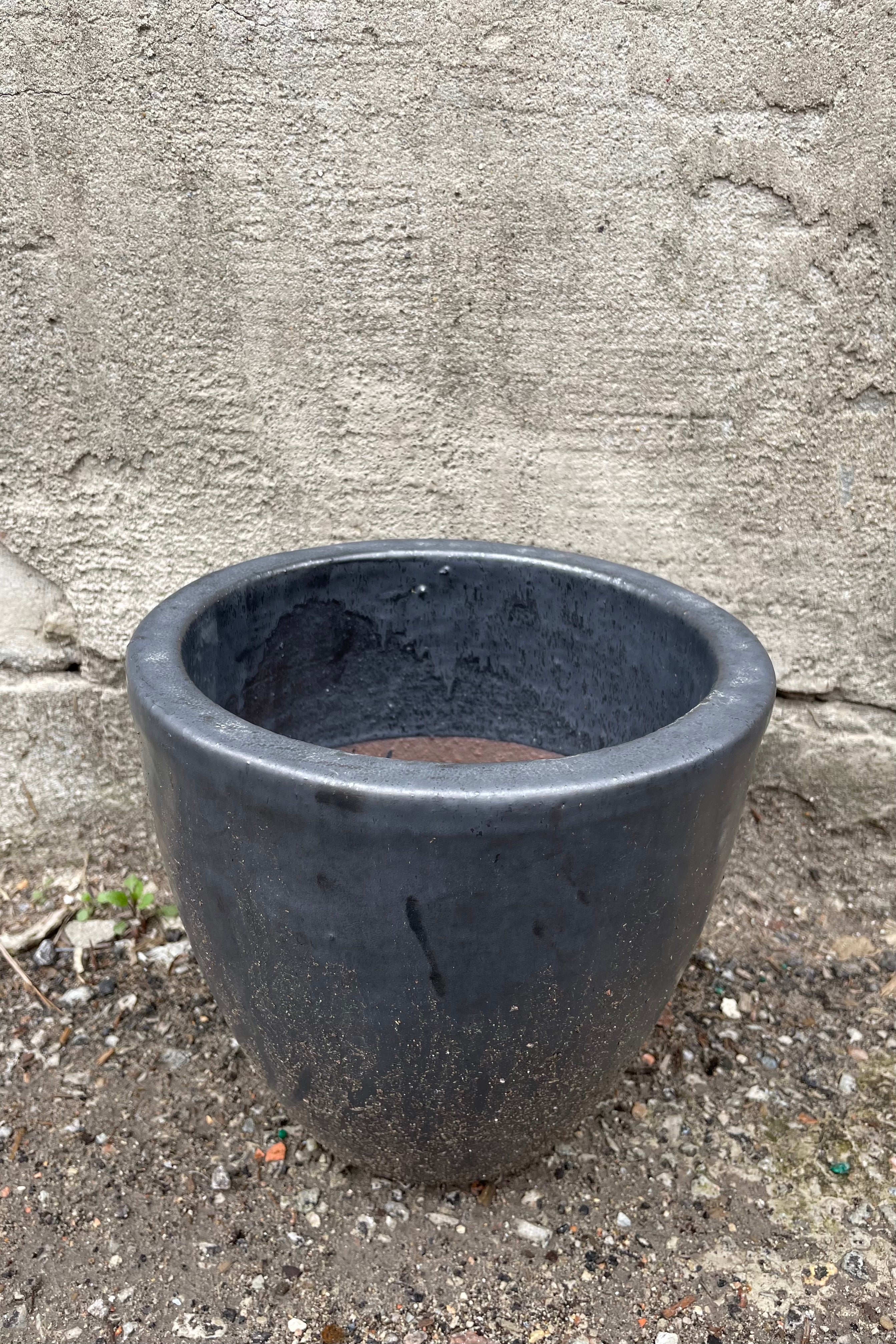 detail of the top of Egg Ceramic Planter Graphite Small against a grey wall