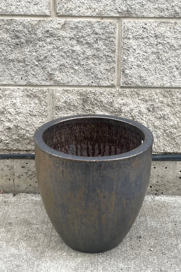 A full frontal view of Egg Ceramic Planter Heavy Metal Medium against concrete backdrop
