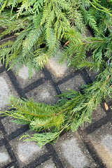 Garland created with a mix of Douglas fir and cedar sitting on a gray brick background. 