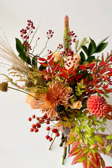 Floral arrangement 'Harvest Moon' by Sprout Home being held against a white wall. 