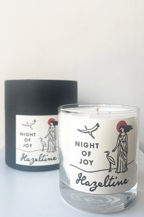 A view of candle and packaging of Hazeltine Candle night of joy against white backdrop
