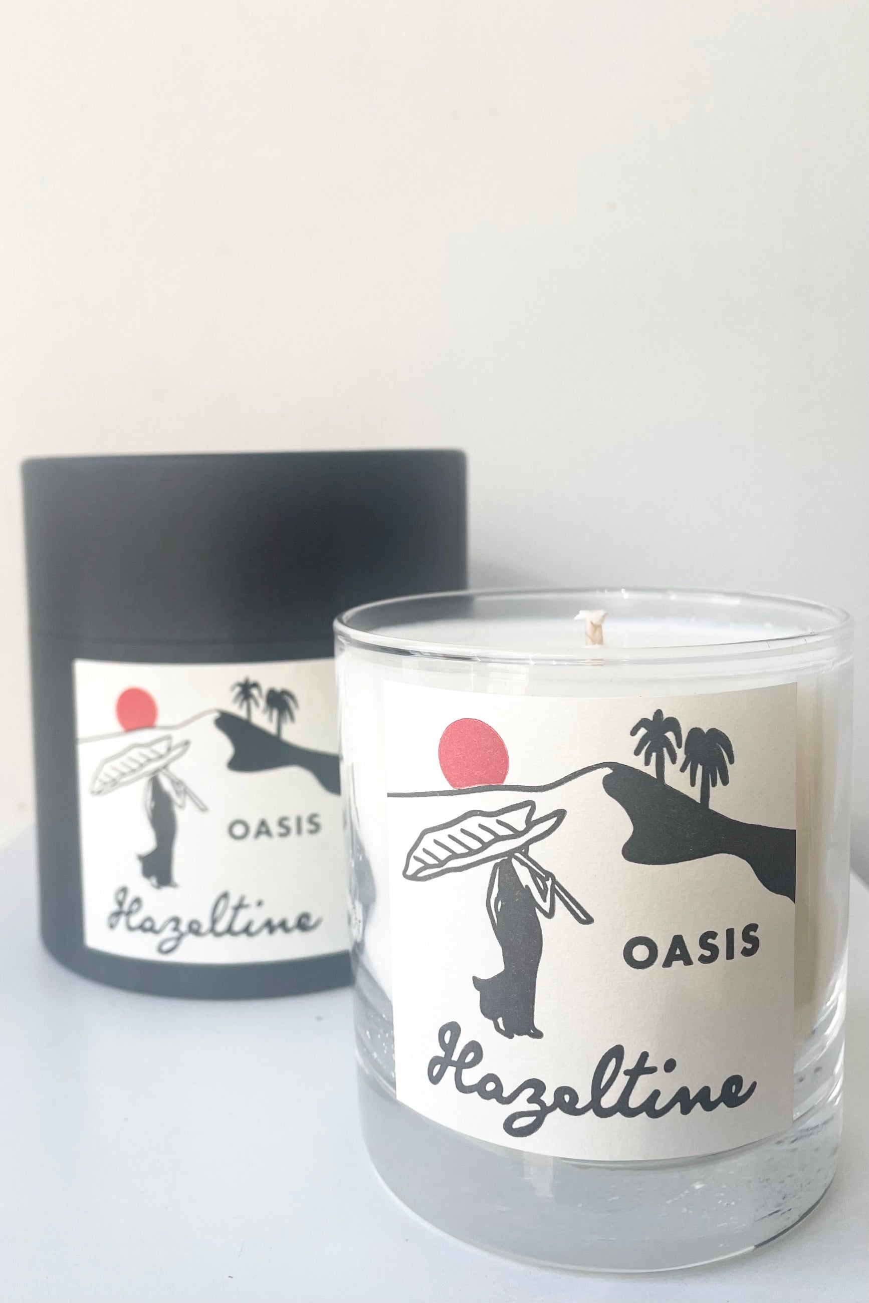 A view of candle and packaging of Hazeltine Candle oasis against white backdrop ©Sprout Home