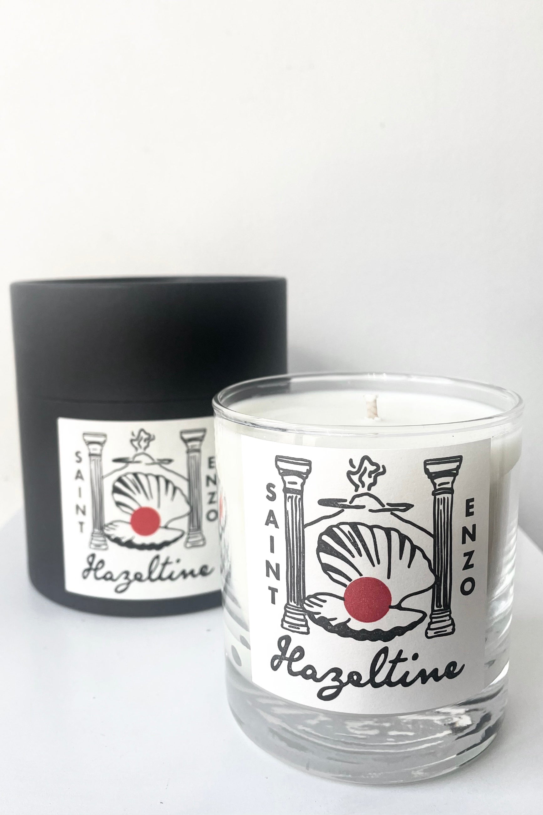 A view of the packaging and candle of Hazeltine Candle saint enzo against white backdrop ©Sprout Home