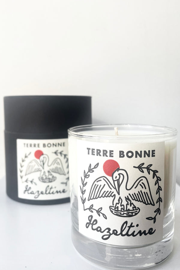 A view of the packaging and candle of Hazeltine Candle terre bonne against white backdrop