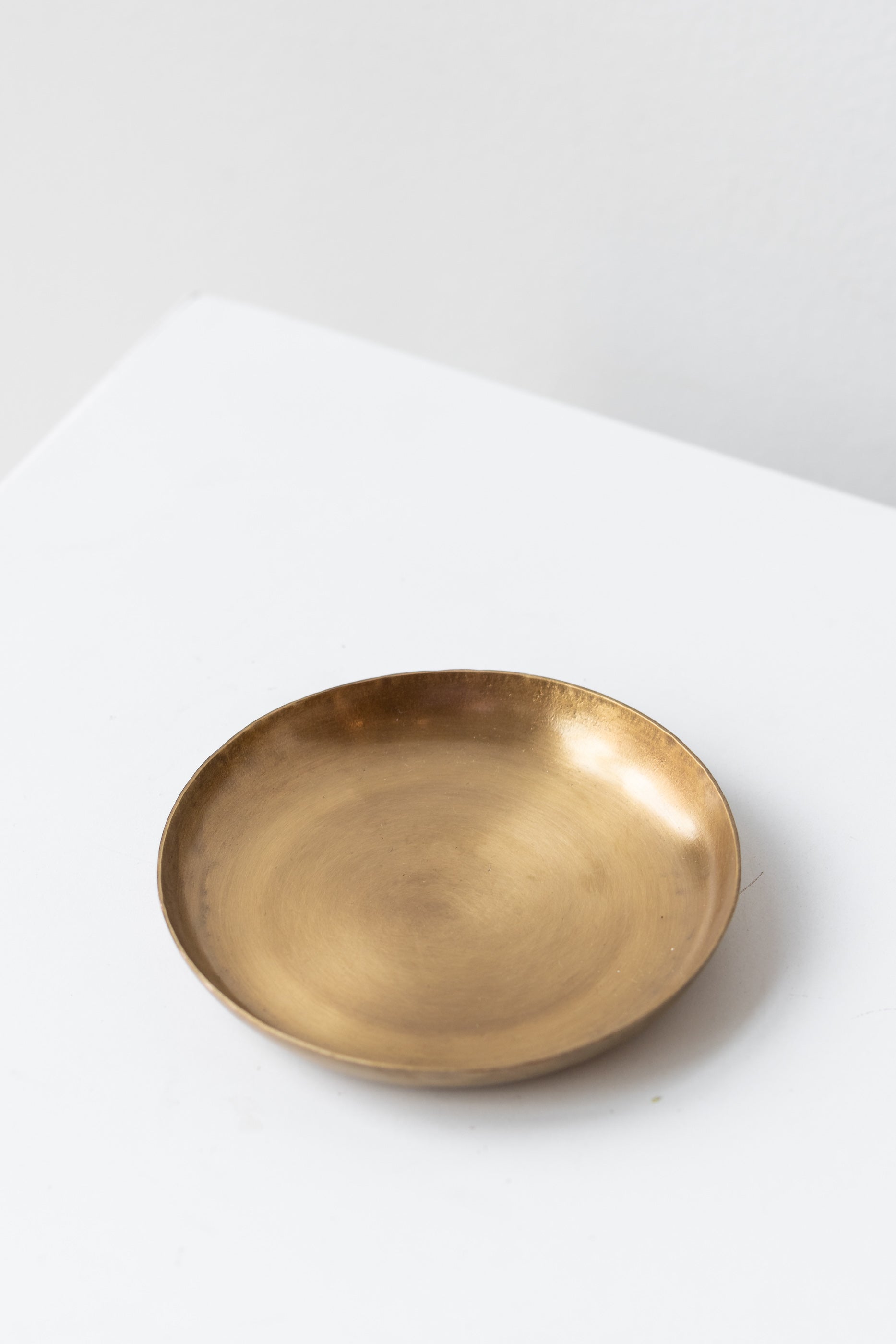 Fog Linen Work small brass round plate on a white surface in a white room