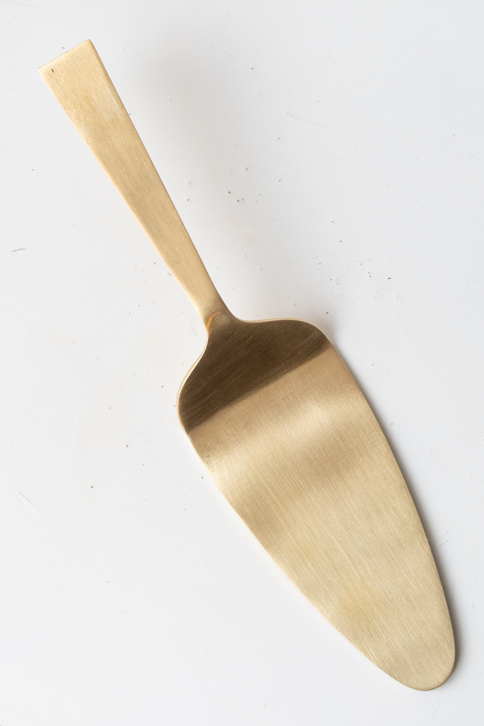 Cake Server brass against a white background