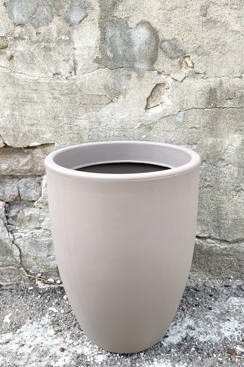 A frontal view of the 16" Porto Planter in Taupe against a concrete backdrop
