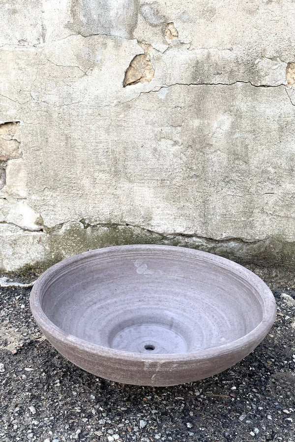 An overhead view of Ada Clay Bowl & Saucer grey 40cm against concrete backdrop