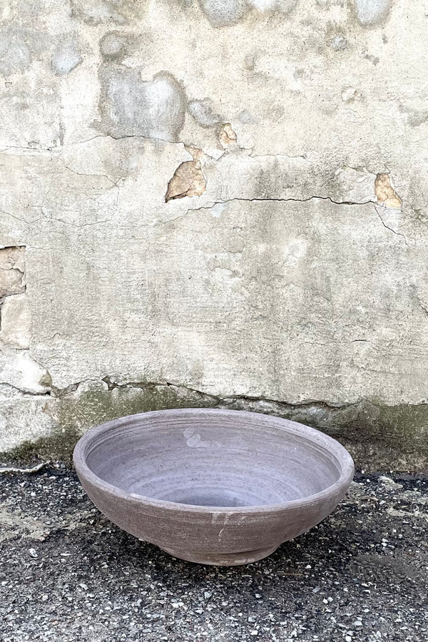 A frontal view of Ada Clay Bowl & Saucer grey 40cm against concrete backdrop