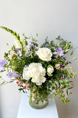 Dawn floral arrangement by Sprout Home sits on white pedestal in a white room