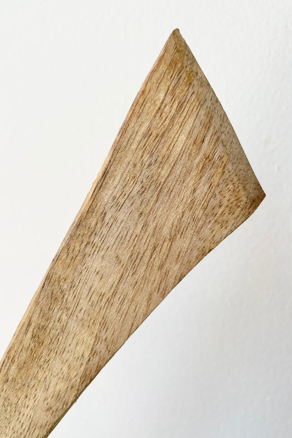 detail of Fog linen work mango wood spatula held in front of white background