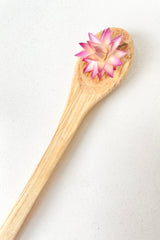 Mango Wood Spoon, with one pink dried floral on the spoon 13cm against a white background