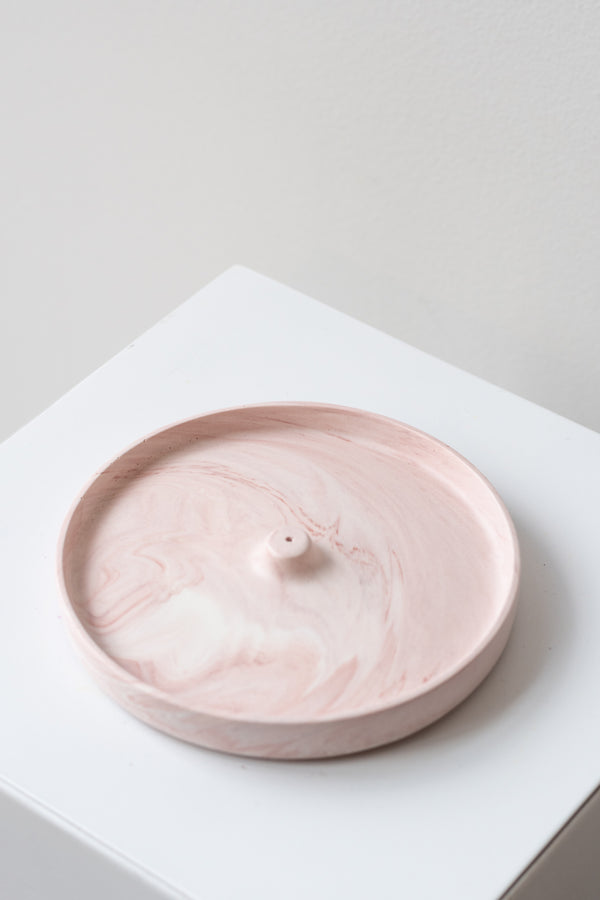 The Northern Habitat Incense Tray blush marble on a white surface in a white room