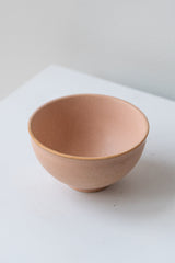 Orange Ishi teacup by Miya Company Inc sits on a white surface in a white room