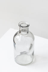 Grey medicine glass bud vase in front of white background
