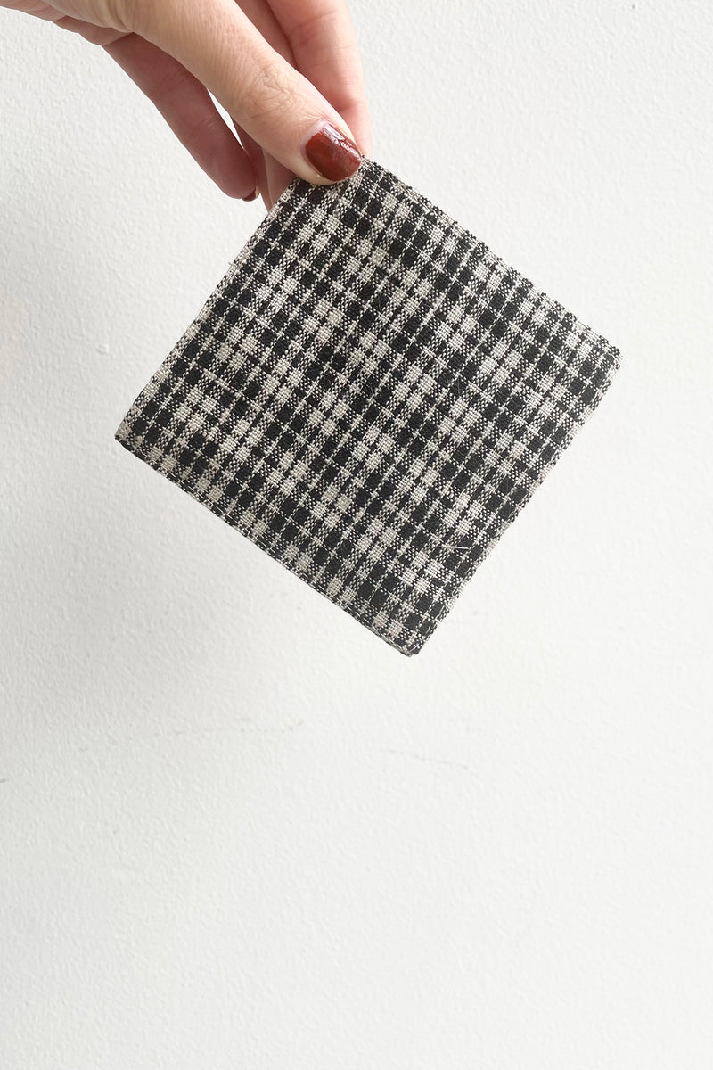 A hand holds the Carole Linen Coaster against a white backdrop