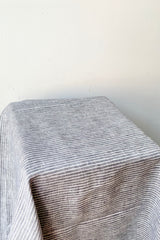 A view of the large grey with white stripe linen tablecloth against a white background