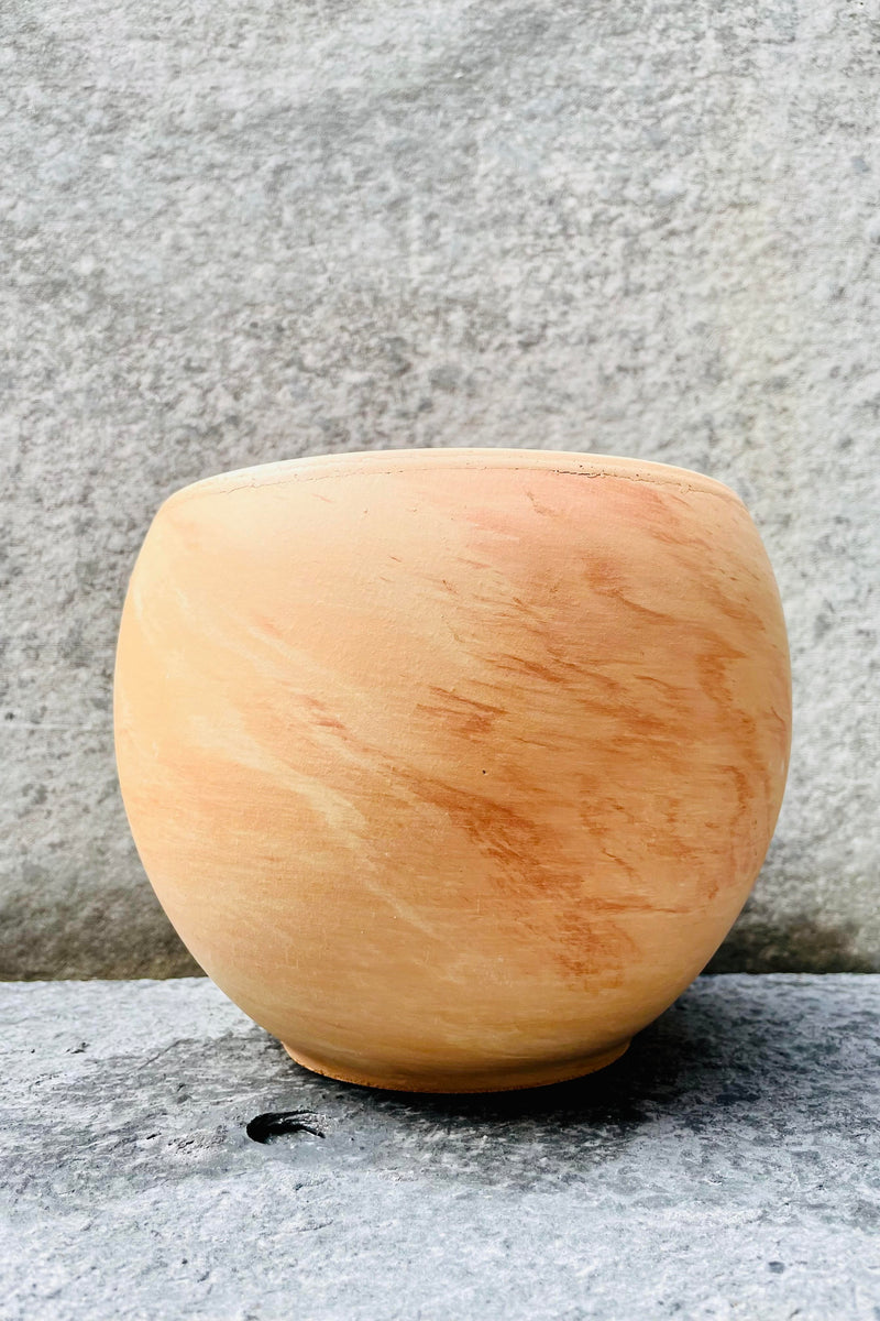 The 7.75 inch, light marble Luna Sphere Pot sits against a grey backdrop.