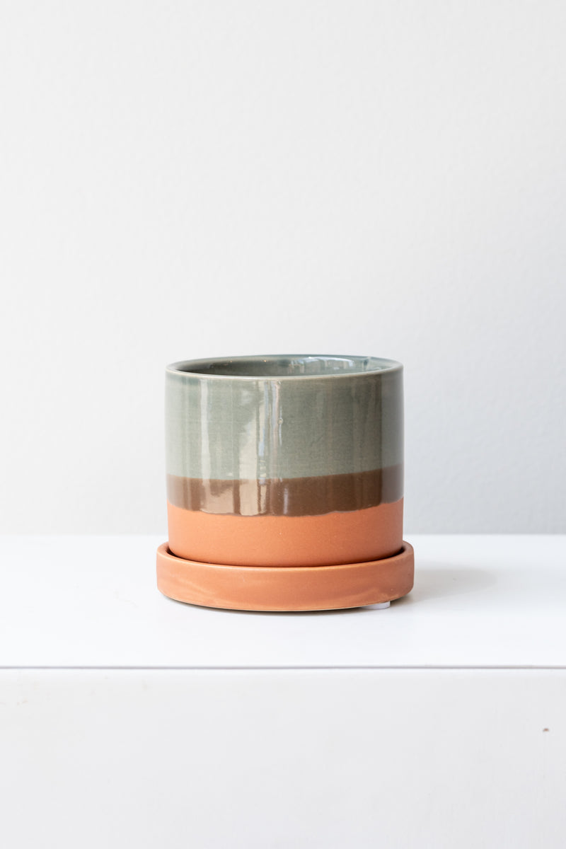 Small Terracotta Minute Pot sits on a white surface in a white room