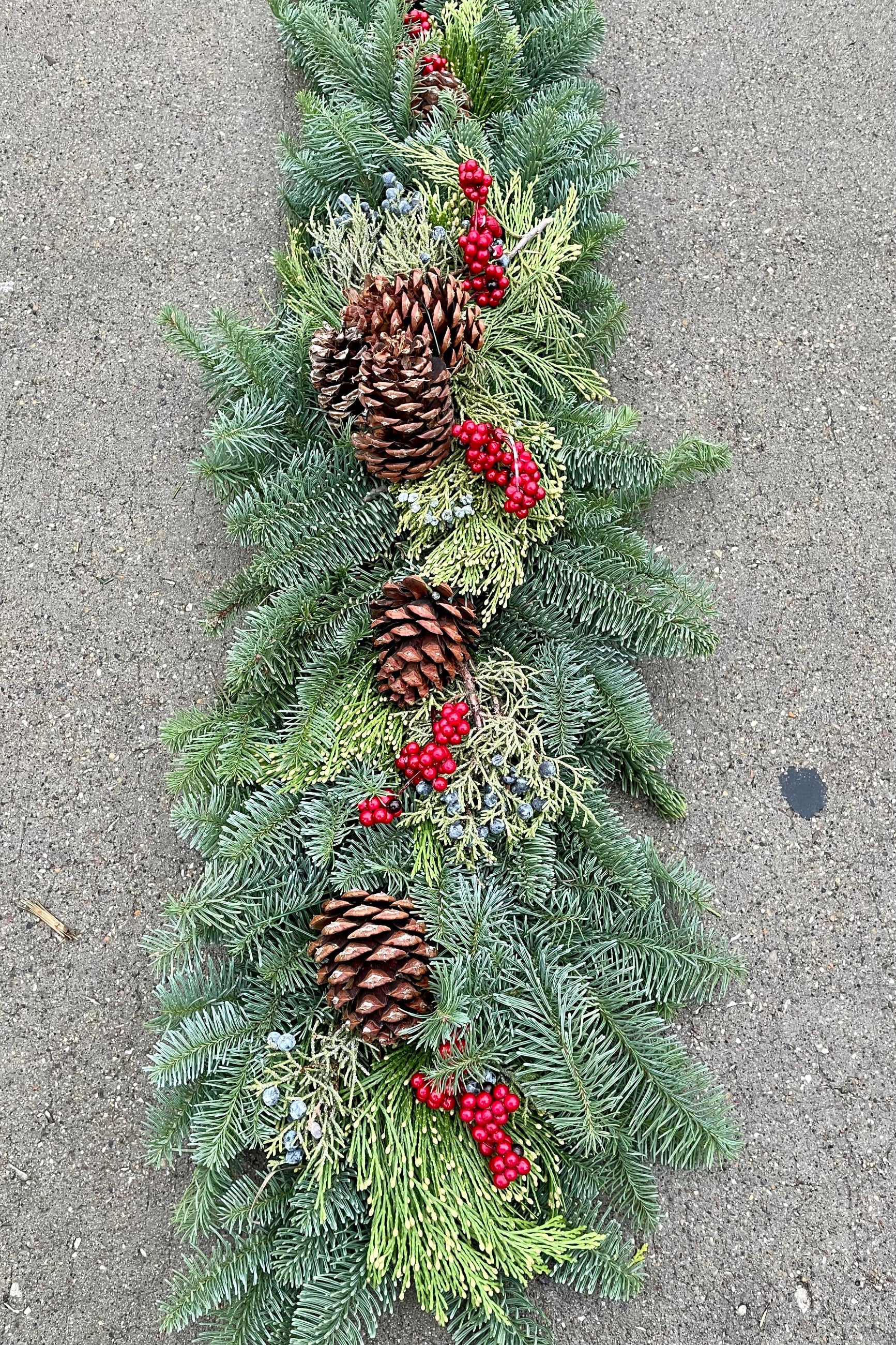 Mantle swag made of evergreen, pine cones and faux canella berries. ©Sprout Home