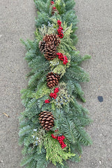 Mantle swag made of evergreen, pine cones and faux canella berries.