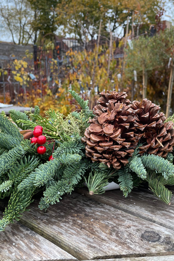 Deluxe swag detail of pine cones and evergreen.