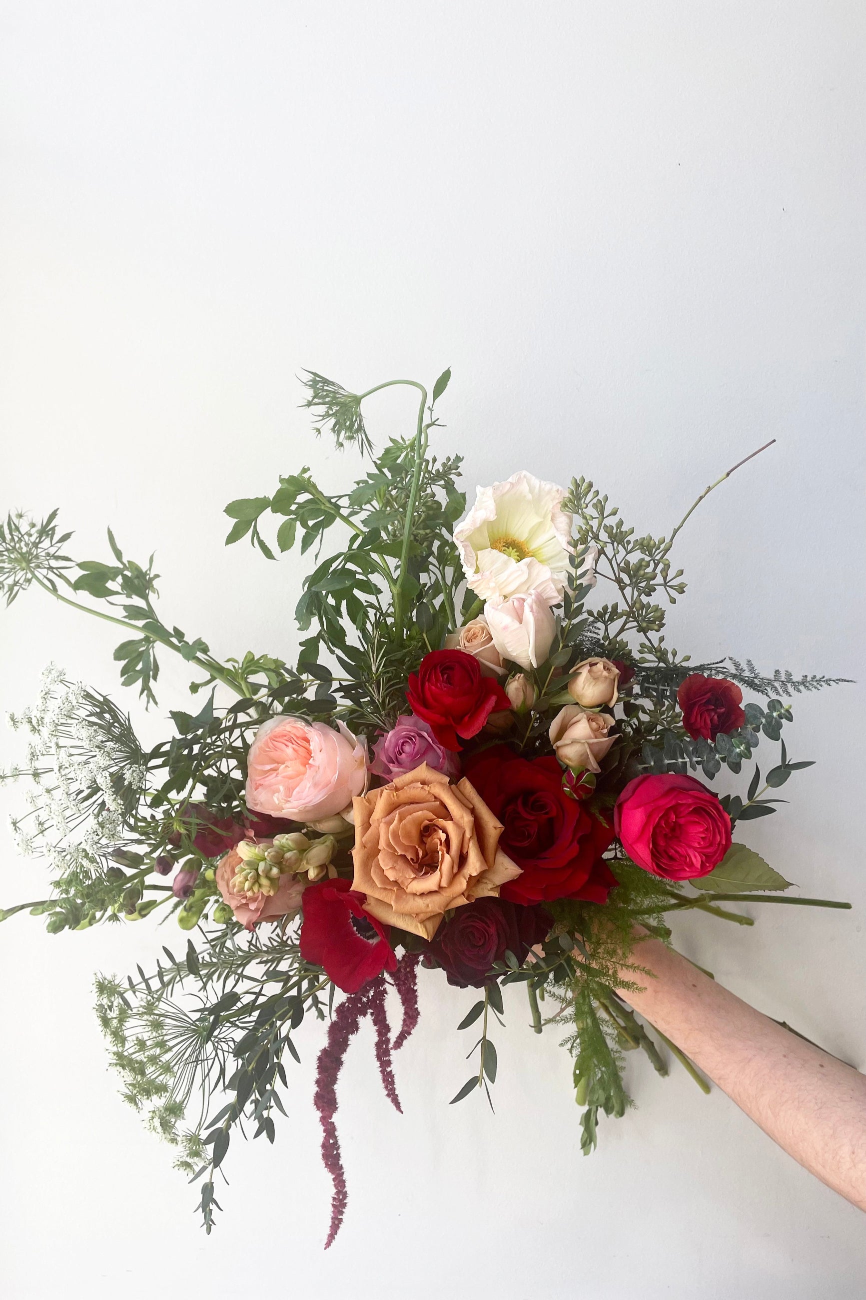 A hand holds an example of fresh Floral Arrangement Modern Love from Sprout Home Floral in Chicago for Valentine's Day ©Sprout Home #size_$130