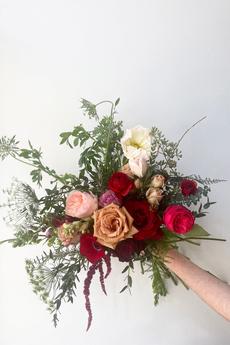 A hand holds an example of fresh Floral Arrangement Modern Love $125 from Sprout Home Floral in Chicago for Valentine's Day