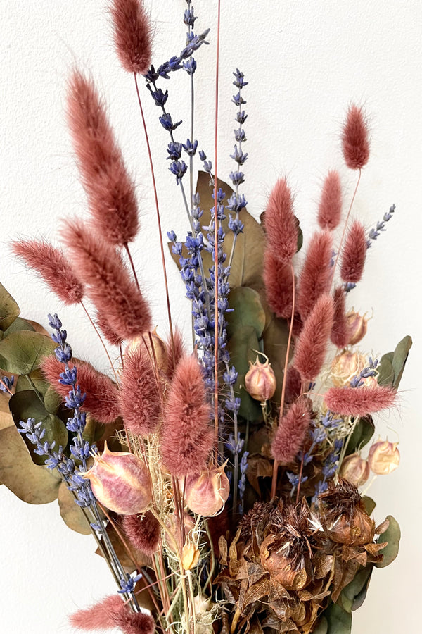 A detailed photo of example components that make up Preserved Floral Arrangement Mulled Wine from Sprout Home Floral in Chicago. The dried floral arrangement features autumnal colors like deep reds and browns alongside greenery and a pop of purple.