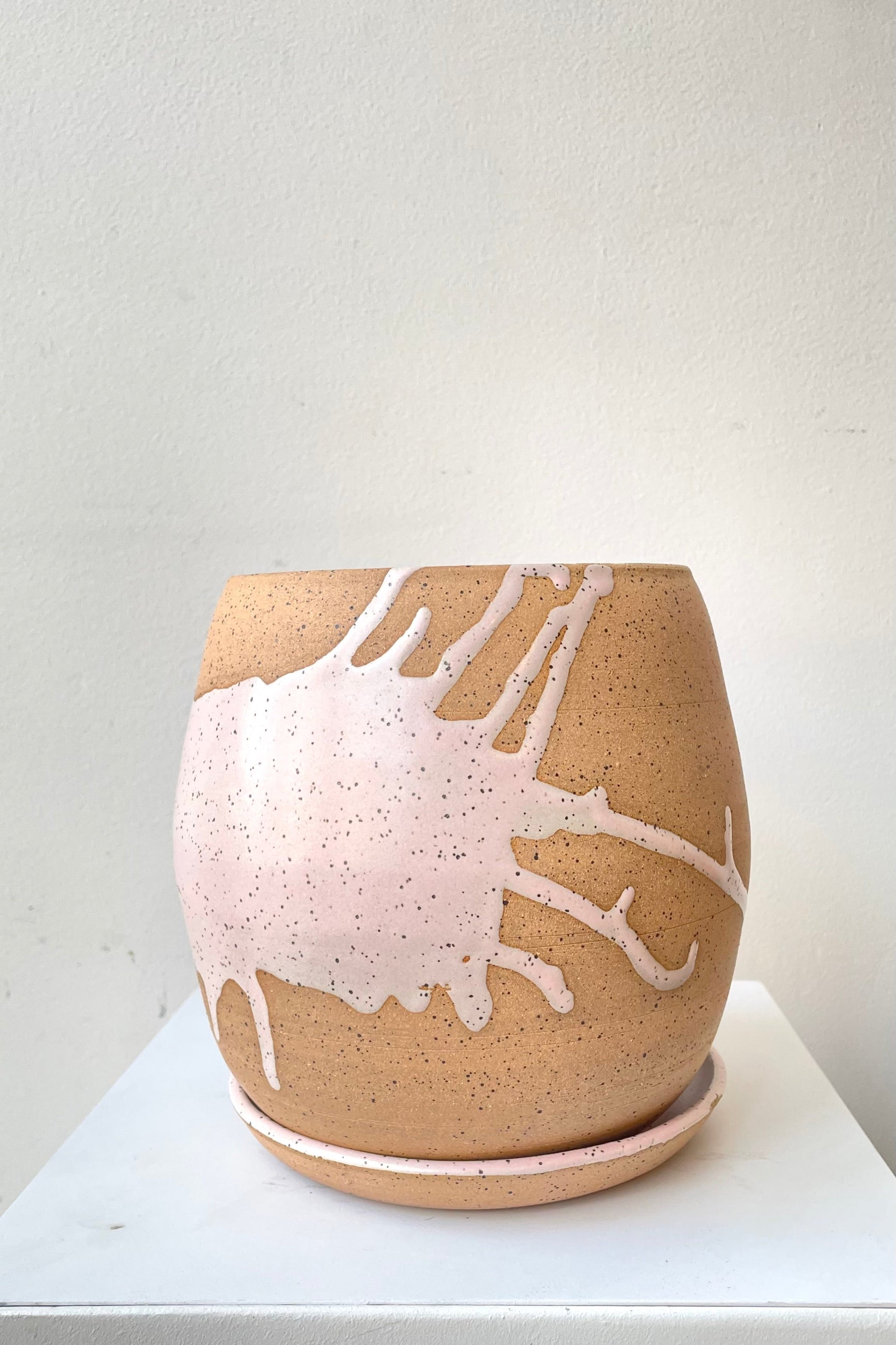 A frontal view of the 6.5" orb pot and saucer in pink against a white backdrop ©Sprout Home 