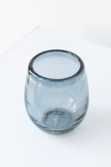 Small smoke oval colored wine glass on a white table in a white room