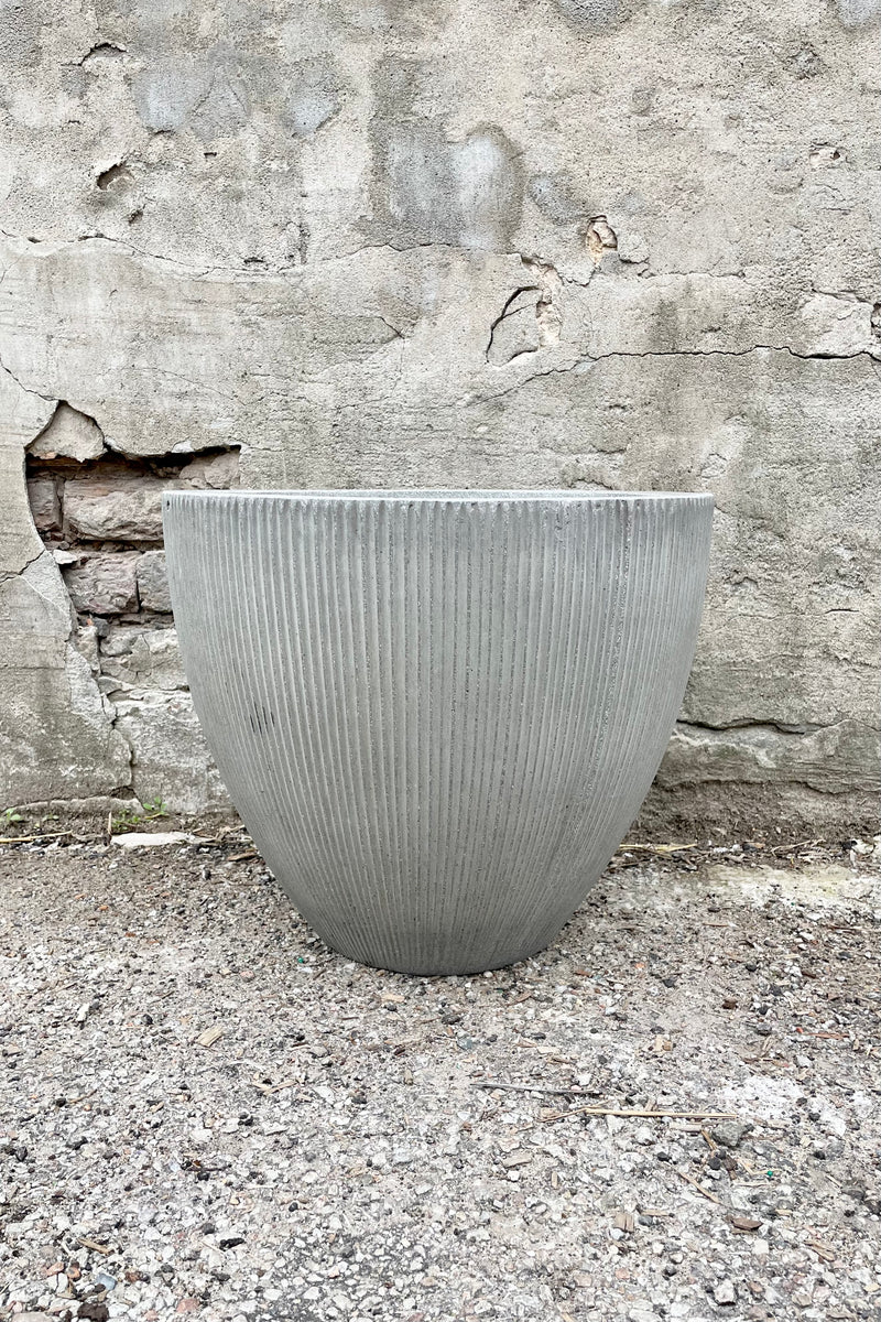Jesslyn Pot vertical ridged light grey extra small against a grey wall