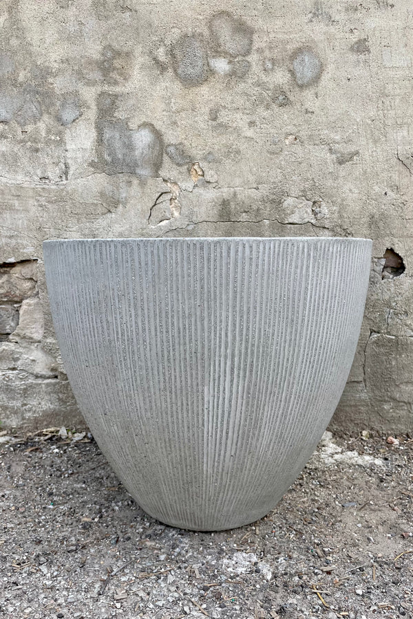Jesslyn Pot vertical ridged light grey small  against a grey wall