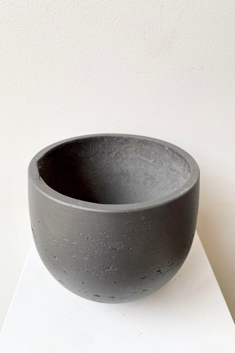An aerial view of the Mini Orb black washed small pot against a white backdrop.