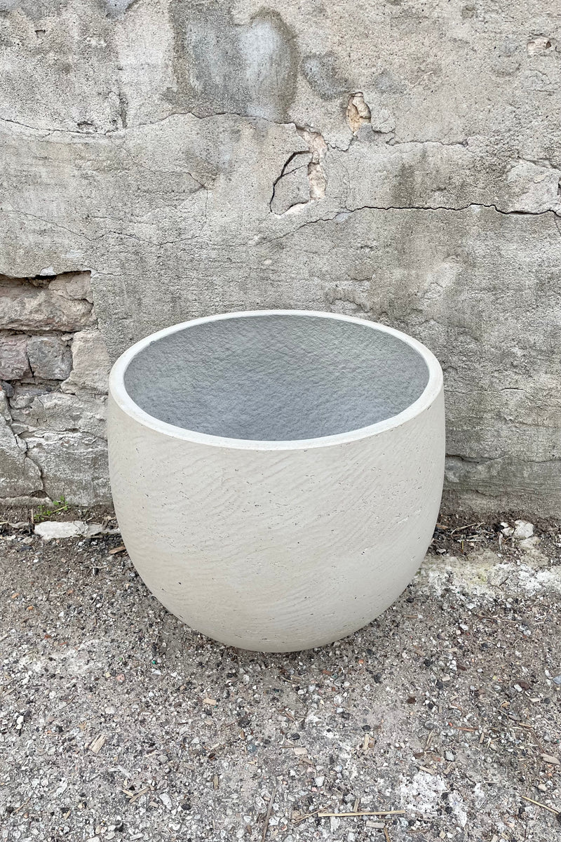 Detail of the top of the Mini Orb Pot Grey Washed Extra Large against a grey wall 