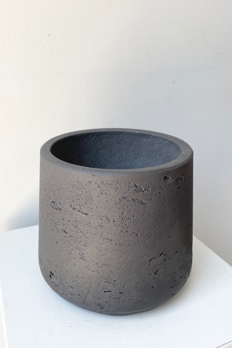 detail of the top of Patt Pot black Washed Medium against a white wall