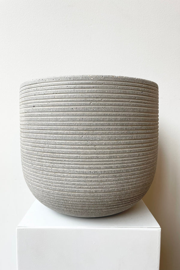 Cody Pot horizontal ridged light grey small against a white wall