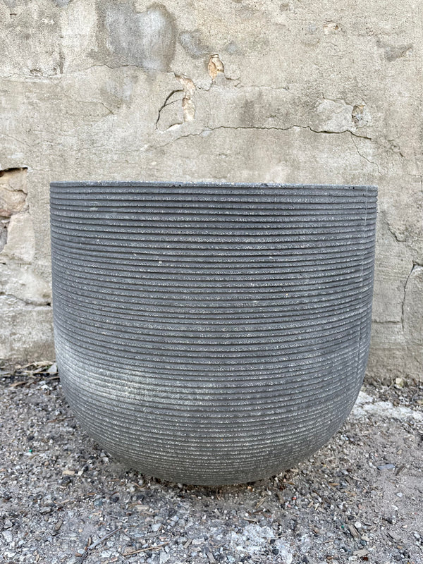 Cody Pot horizontal ridged dark grey large against a grey wall