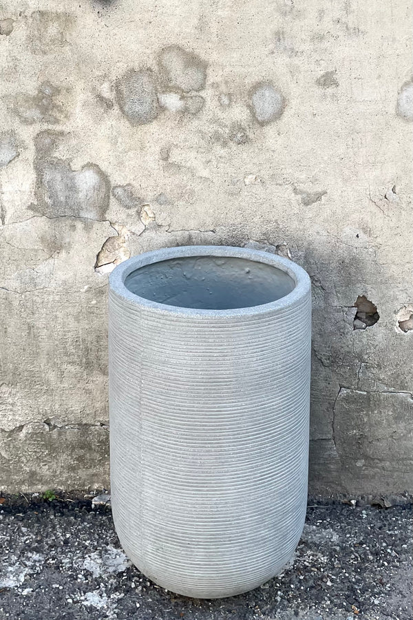 A frontal view of the Cody High Pot horizontal ridged light grey medium against a concrete backdrop