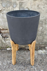 Detail of Charlie Pot & high stand black washed extra large against a grey wall