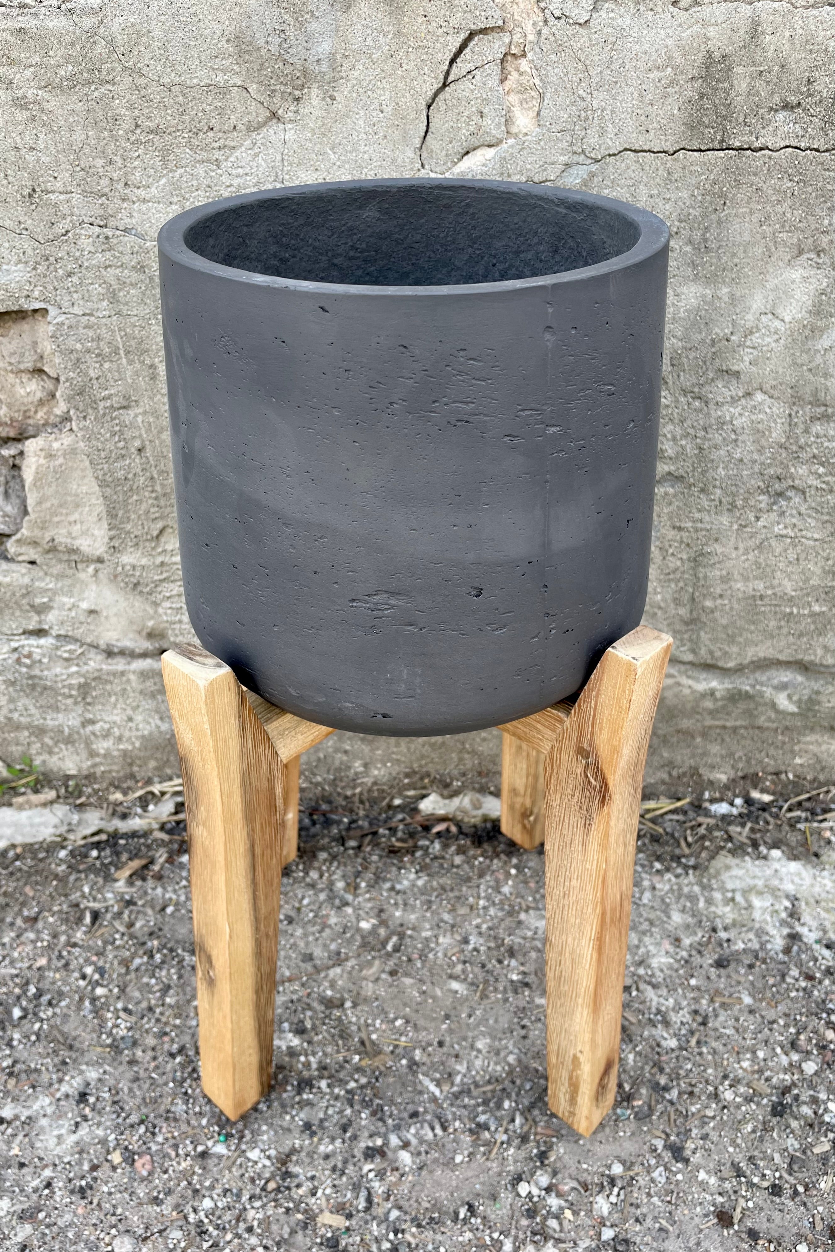 detail of Patt Pot w/ High Feet Black Washed Extra Large against a grey wall